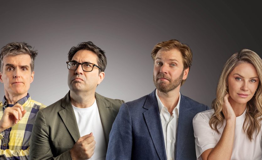 Four adults stand side by side against a gradient grey background, each with a thoughtful or curious expression. Three men wear jackets and shirts, and the woman on the far right wears a white top and touches her neck.